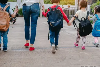 Kinderen die hand in hand lopen met een volwassene